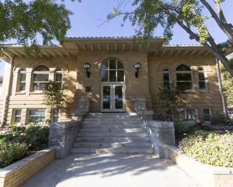 The historic Carnegie building in Turlock, with arched windows and steps leading to the entrance.