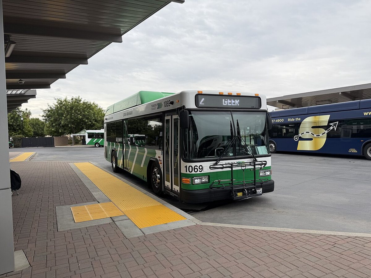 A green Turlock Transit bus, number 1069, at the transit center.