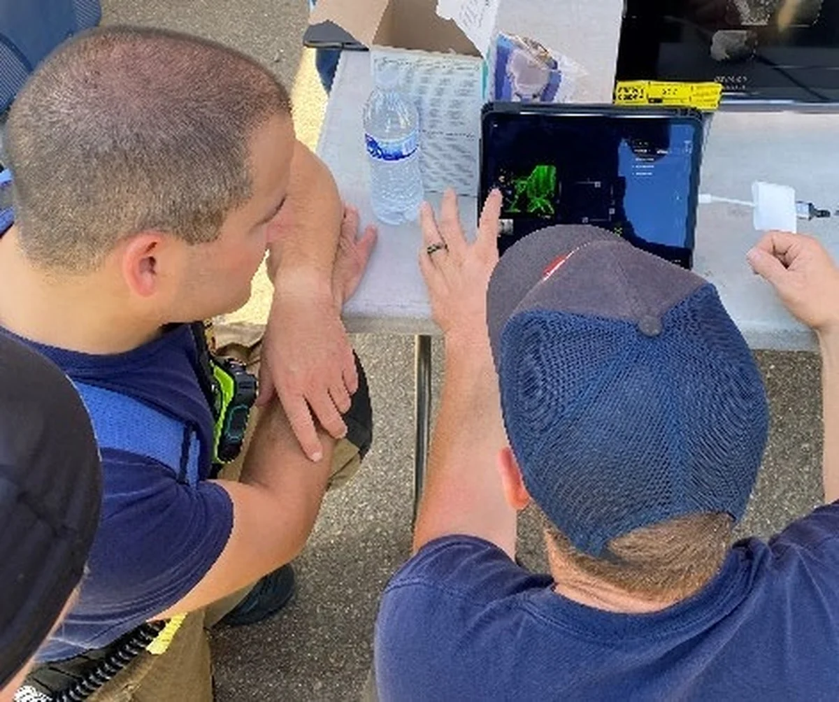 Firefighter evaluators reviewing a C-THRU Visual Command tablet during the San Diego field assessment.