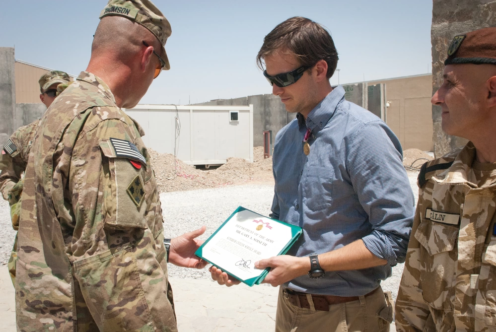 Gary Soiseth receiving the Superior Civilian Service Award from Brig. Gen. John C. Thomson in Kandahar, Afghanistan, August 10, 2013.