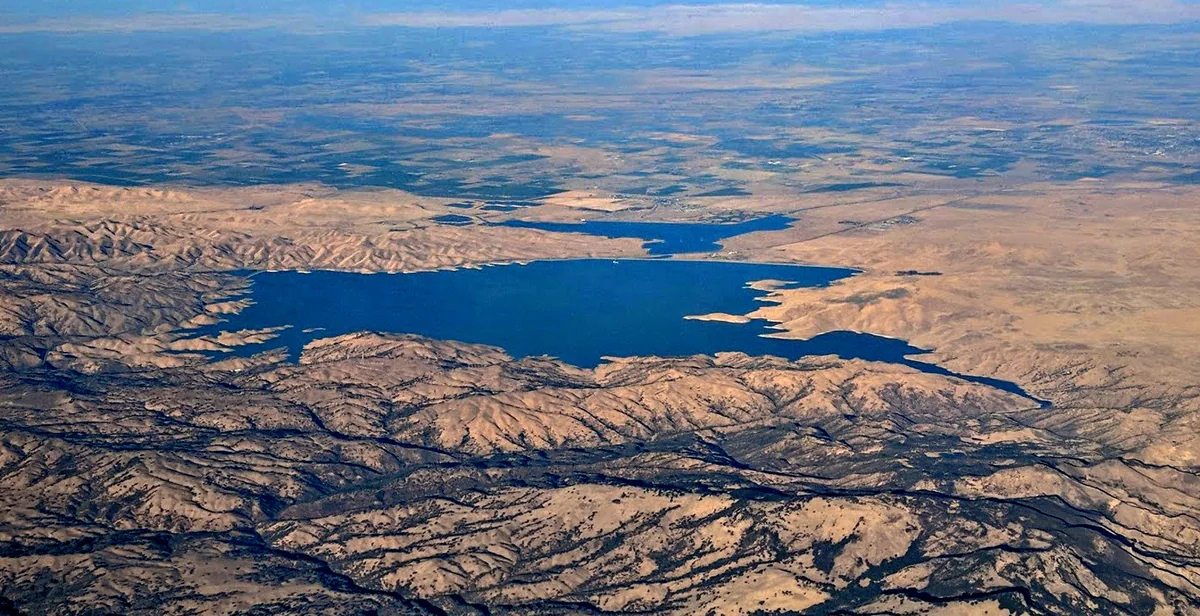 Aerial view of San Luis Reservoir in the hills, with the smaller O’Neill Forebay beyond it toward the Valley.