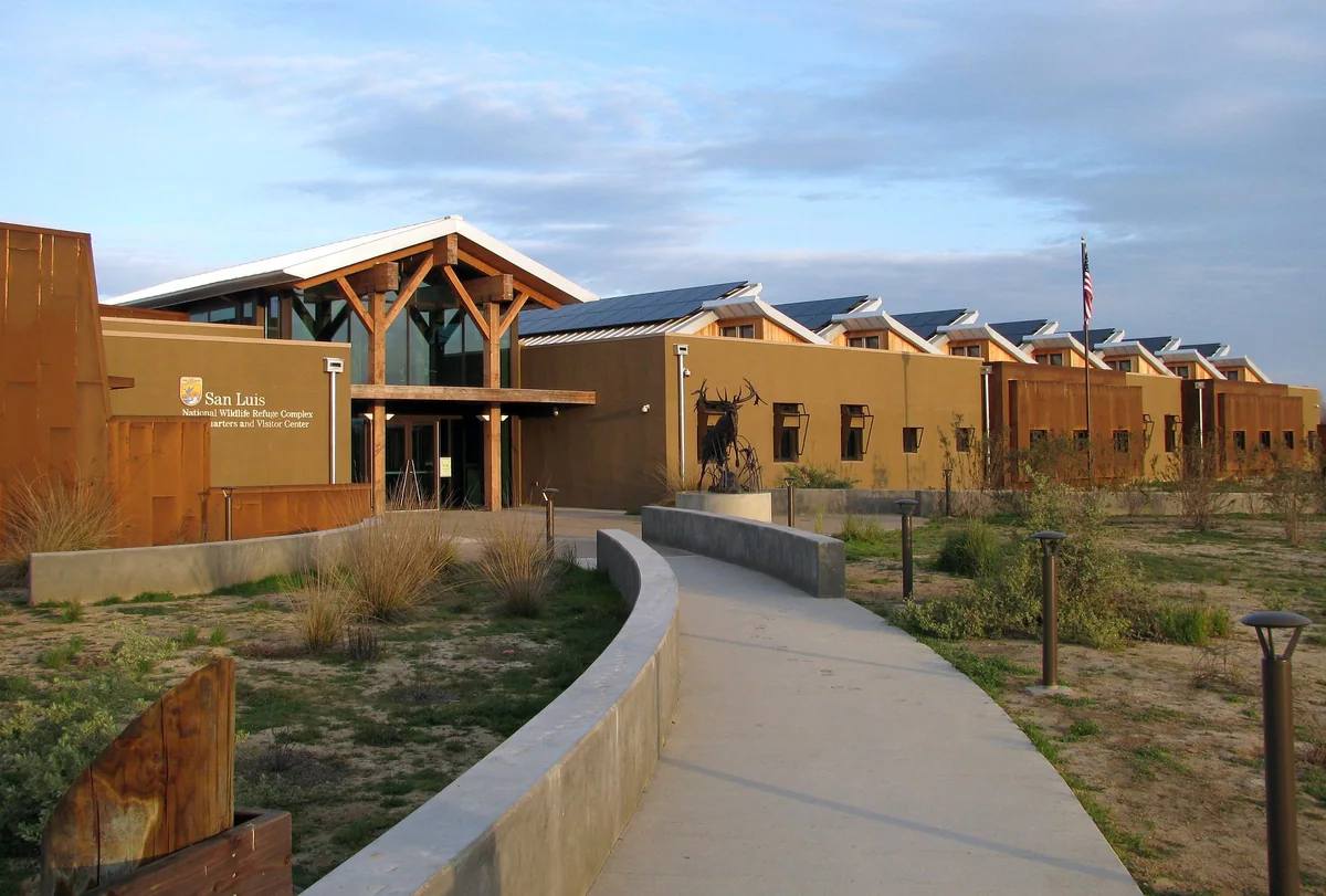 The San Luis National Wildlife Refuge visitor center, with solar panels and an elk sculpture outside the entrance.