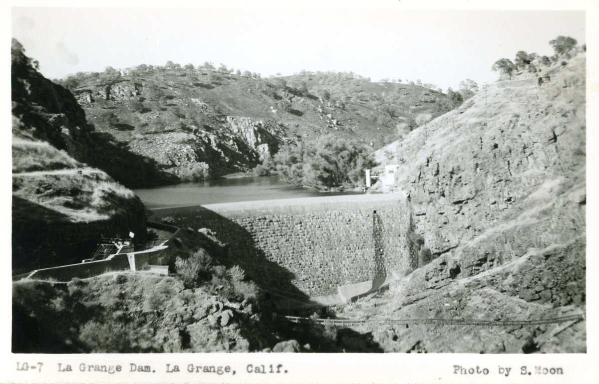 Historic black-and-white postcard showing La Grange Dam across the Tuolumne River gorge
