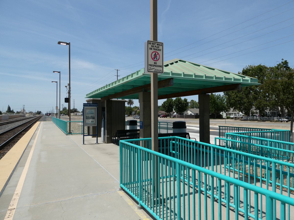 Sheltered waiting area and railway platform at Turlock–Denair Amtrak station.